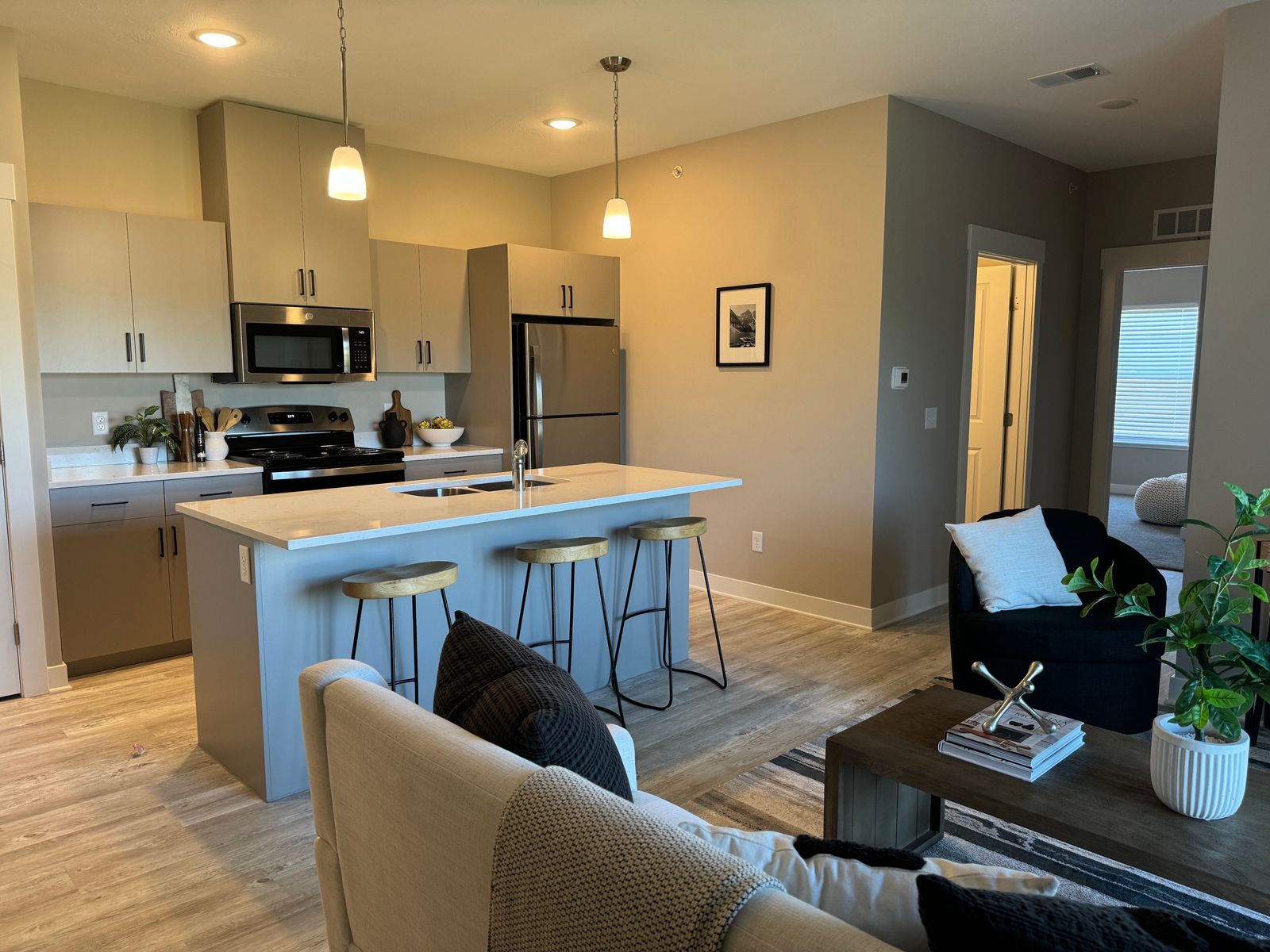 Kitchen with quartz island, bar stools and stainless appliances